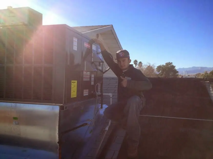 HVAC technician performing Air Duct Repair on a rooftop unit in Leonardtown