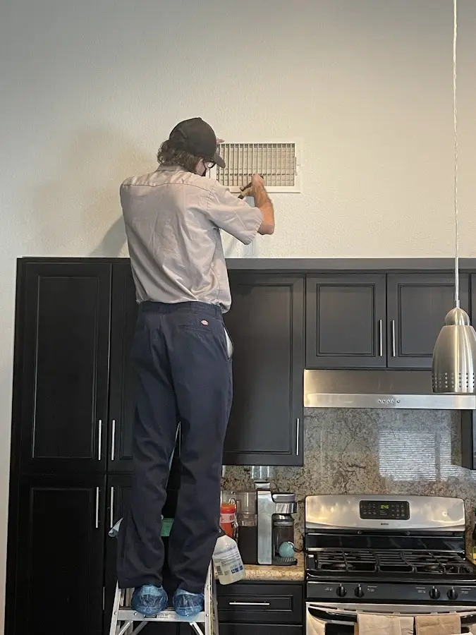 Technician inspecting an air vent during HVAC service in Leonardtown